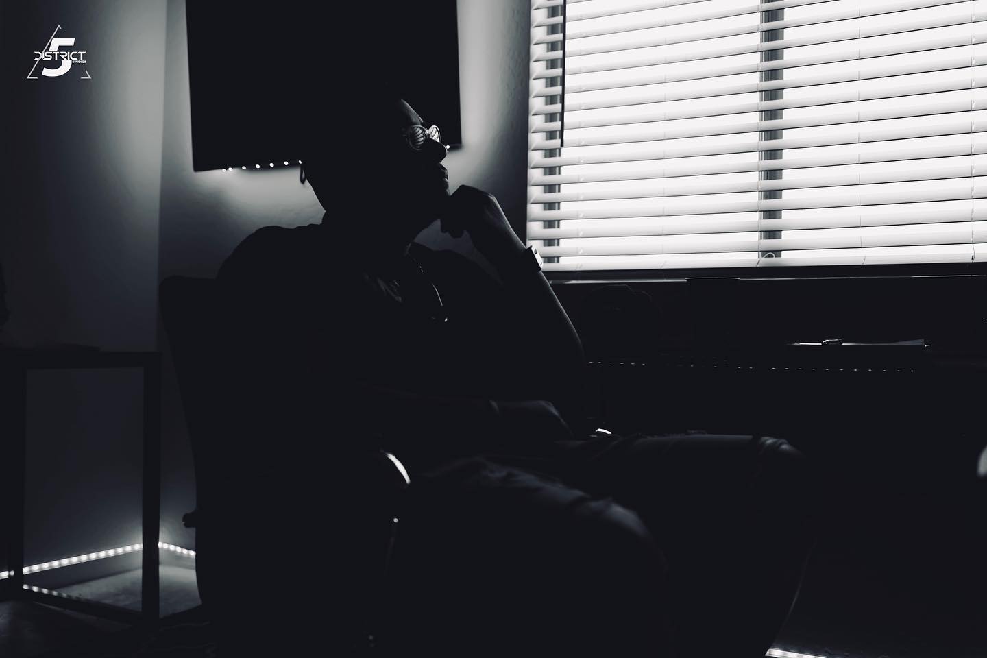 Black and white photo of music artist thinking