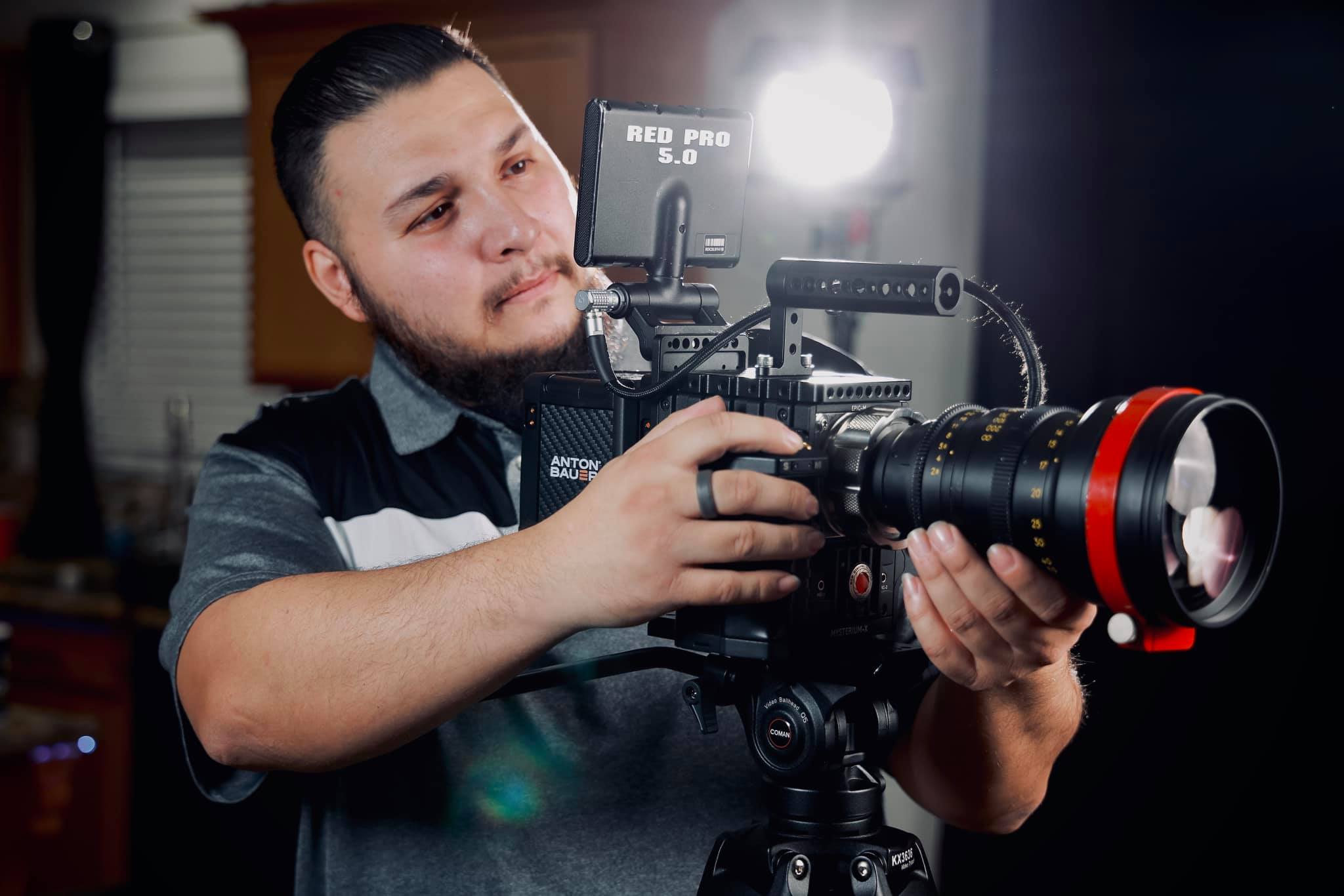 Photo of camera man adjusting camera settings